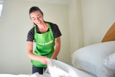 merry maid making a bed